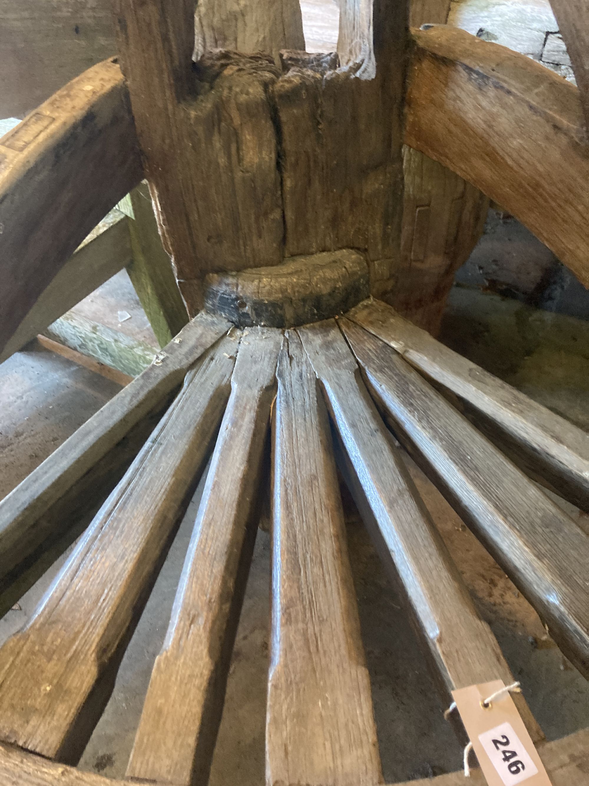 A weathered hardwood cartwheel and reclaimed timber garden seat, width 88cm depth 70cm height 170cm